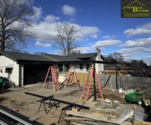A spacious, modern metal carport with a dark gabled roof and white support columns.