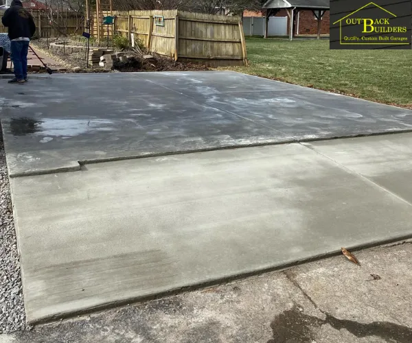 view of a freshly poured concrete driveway leading to a residential garage