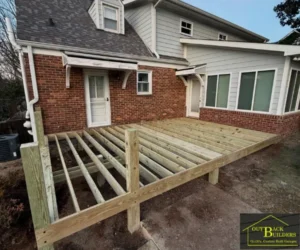 The structural wooden frame of an outdoor deck under construction.