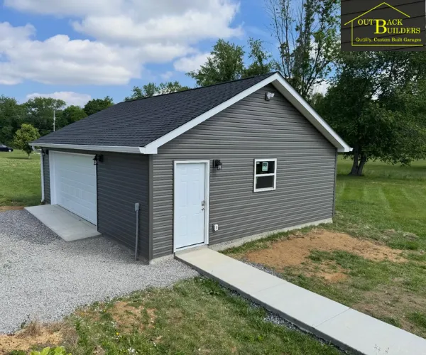 A newly constructed detached two-car garage featuring light grey siding