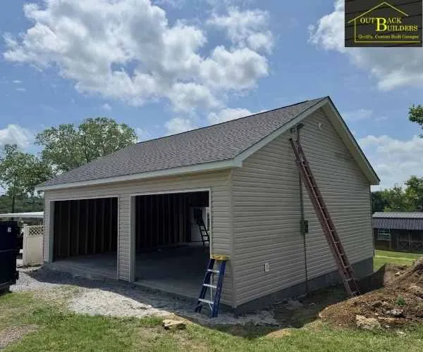 an asphalt shingle roof, and open garage bays, built by a garage builder